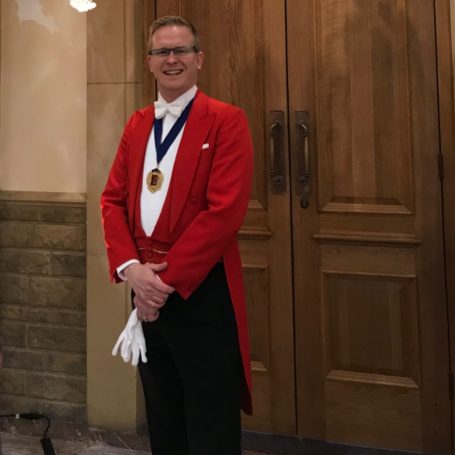 Toastmaster Dan in a red tailcoat ready to host a wedding celebration